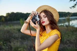 mujer fotógrafo con cámara en manos un instantánea de naturaleza Fresco aire estilo de vida foto