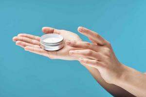 jar of cream in hands dermatology skin care cosmetics photo