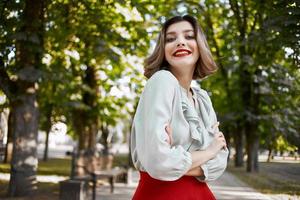 bonito mujer en rojo falda en el parque caminar estilo de vida Fresco aire foto