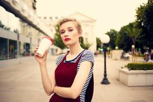 a woman with glasses walks around the city a glass with a drink leisure communication photo