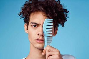 curly guy with a comb hair lifestyle blue background photo