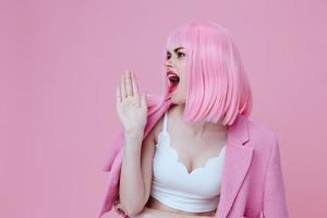 Beautiful fashionable girl gestures with his hands with a pink jacket color background unaltered photo