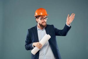 A man in a suit in an orange hard hat blueprints in the hands of a construction engineer photo