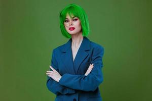 retrato de un encantador dama vistiendo un verde peluca azul chaqueta posando verde antecedentes inalterado foto