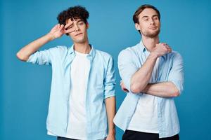 two men in shirts stand next to communication blue background photo