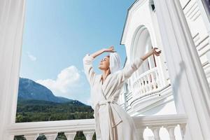 pretty woman standing on the balcony looking at the mountains vacation in the mountains in summer unaltered photo