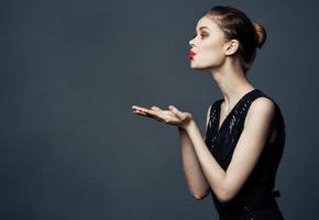 Woman shows emotions with hands to the sides on gray background Copy Space photo