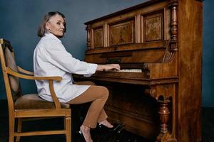 woman music teacher sitting near the piano photo