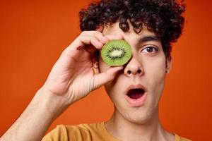 guy with kiwi curly hair near eyes cropped view red background photo