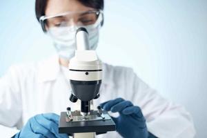 woman looking through a microscope laboratory research science experiment photo