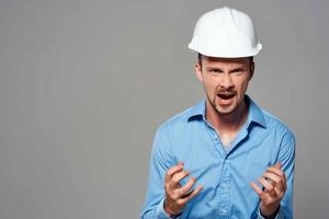 alegre masculino ingeniero en blanco construcción casco profesional trabajando foto