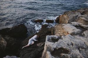 woman in white wedding dress on sea shore wet hair view from above photo