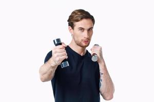 guy athlete in a black t-shirt with dumbbells in his hands on a white background photo