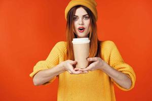 pretty woman in yellow hat with a cup of hot drink in hands emotions isolated background photo