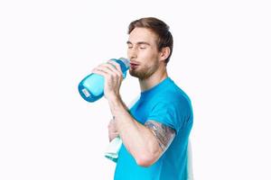 sporty man with towel on shoulders workout water bottle cropped view photo