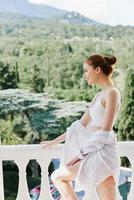 Portrait of young beautiful woman stands on a balcony terrace in lingerie sunlight beautiful view Lifestyle photo