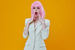 Woman in white suit pink wig posing on yellow background photo