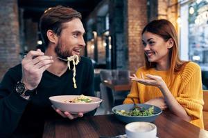 cheerful man and woman sitting in a cafe communicating emotions photo