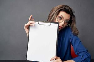 business woman with glasses sits at the table while holding Copy Space photo