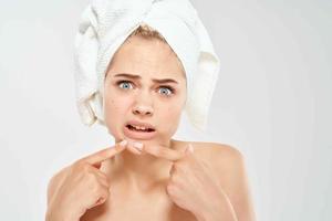 woman with bare shoulders with a magnifying glass in her hands black dots on her face photo