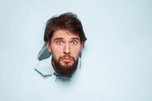 A bearded man peeps out from behind the wall dissatisfaction emotions office official photo