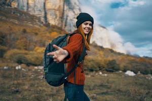 mujer caminante con un mochila viajes en el montañas al aire libre en otoño caído hojas foto