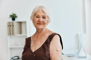 emotional old woman with plaster on her hand covid passport immunization safety photo