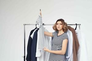 cheerful woman next to clothes fashion fun isolated background photo