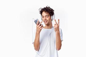 curly-haired guy in headphones with a phone in his hands music technology photo