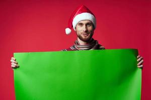 alegre hombre en un Papa Noel sombrero participación un bandera fiesta estudio posando foto