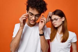 alegre joven Pareja vistiendo lentes emoción naranja antecedentes Moda foto