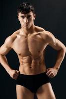 athletic man muscled in dark shorts bodybuilder studio photo