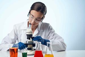 laboratory assistant in a white coat work table microscope diagnostics biotechnology photo