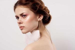 woman with bare shoulders jewelry bright makeup close-up photo