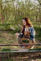 Girl bird farm worker smiles and is happy pouring food into the feeder for the chickens outdoors photo