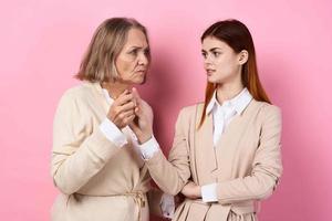 Mom and daughter holding hands caring family together love pink background photo