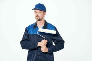 man in working uniform paint roller repair work photo