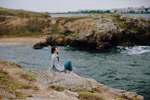 woman beach tourism cloudy weather stone coast female relaxing photo