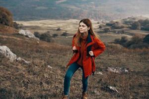 mujer en un chaqueta con un mochila montañas estepa paisaje otoño calentar ropa modelo foto