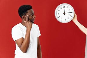 African American holding his finger to his temple looking at the clock Studio red background photo