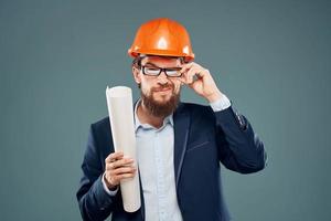 Male engineer wearing a suit in orange paint safety work drawings photo