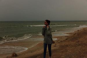 hermosa mujer solo por el Oceano nublado clima contento hembra relajante foto