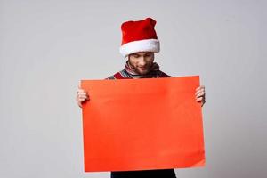 Cheerful man in a christmas hat with Red mockup poster light background photo