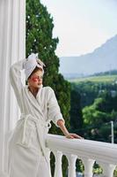 Woman in a bathrobe stands on the balcony of the hote unaltered photo