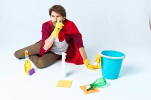 cleaner with cleaning supplies in a red raincoat on the floor of the house interior photo