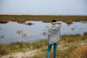 woman in sweater on nature walk landscape photo