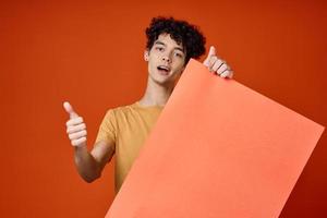 emotional guy with curly hair island in hands advertising red background photo