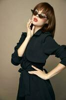 Fashionable woman holds her hand on her belt and touches her face with her hand short hairstyle photo