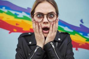 surprised artist with glasses near colorful graffiti on the wall cropped view photo