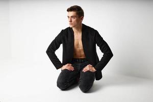 A man sits on his knees black jacket attractiveness modern style photo
